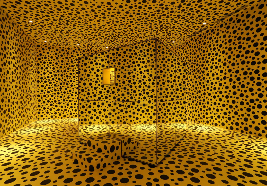 An infinity mirror room full yellow and black polka dots