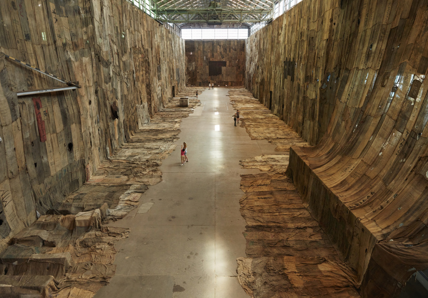 brahim Mahama, No Friend but the Mountains 2012-2020, 2020, charcoal jute sacks, sacks, metal tags and scrap metal tarpaulin, dimensions variable. Installation view (2020) for the 22ndBiennale of Sydney, Cockatoo Island. Courtesy the artist; White Cube; and Apalazzo Gallery, Brescia.
