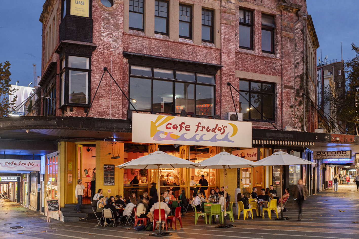 Cafe Freda's, a bar on the corner of Oxford Street, filled with people sitting outside and inside.