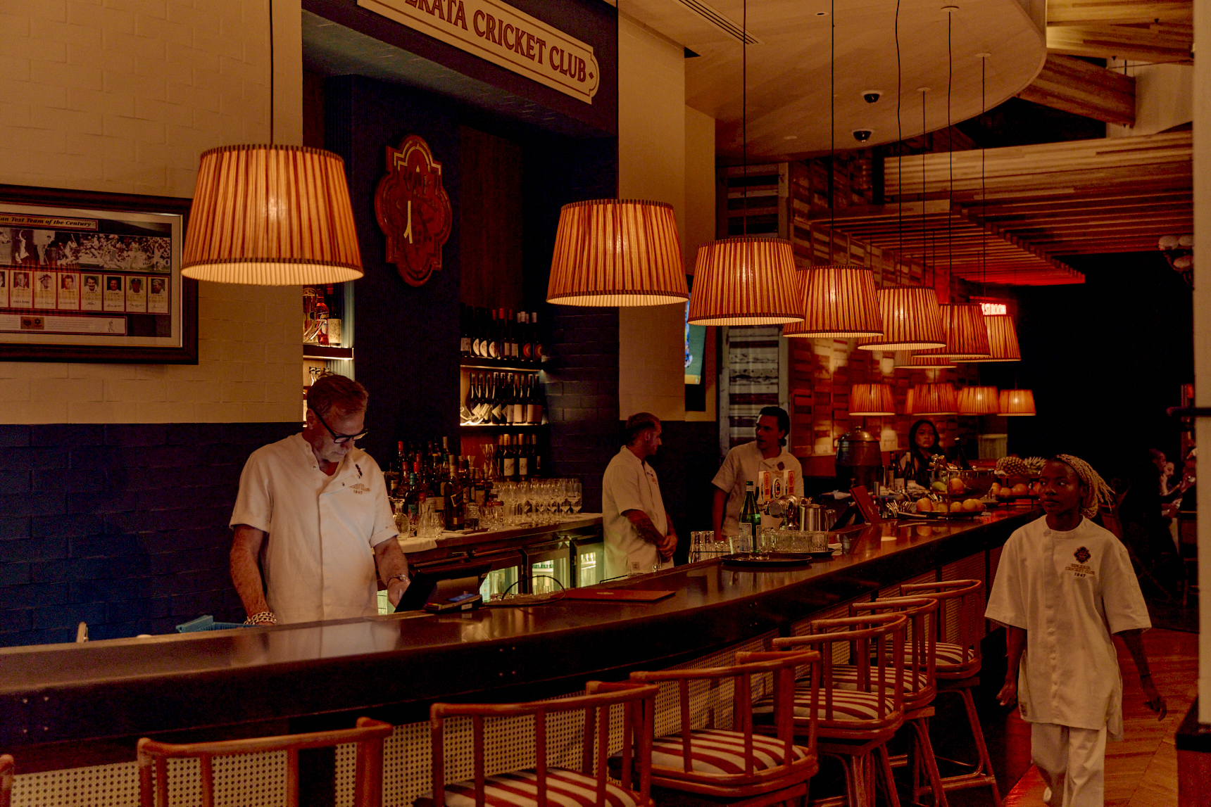 Bartenders behind the front bar at Kolkata Cricket Club.